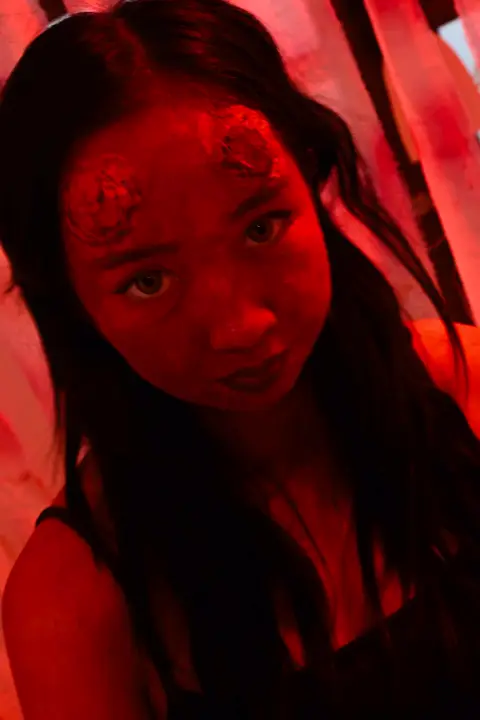 Teammate in blood make-up under red light