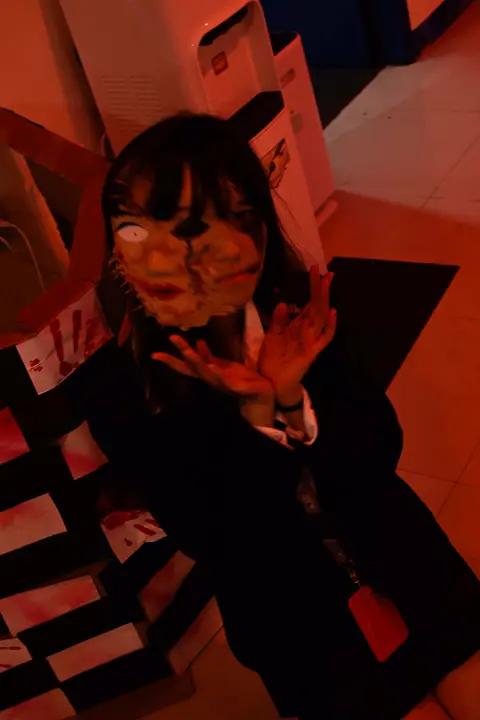 Masked schoolgirl costume under red light