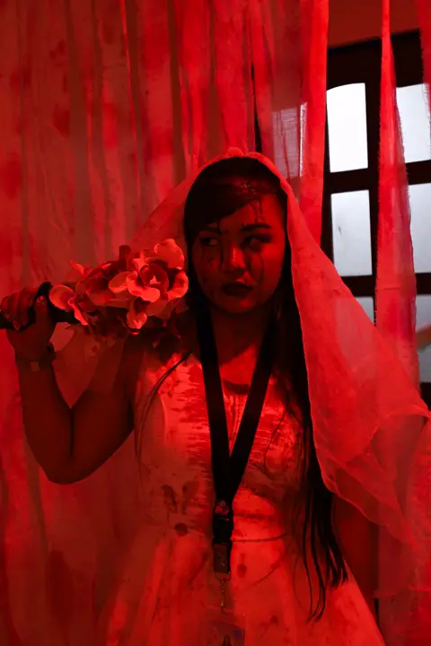 Bride holding a bloody bouquet under red light