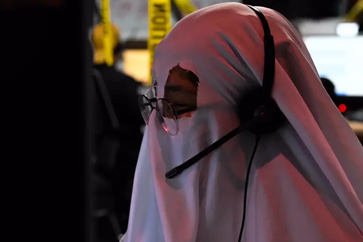 Agent dressed as a sheet ghost, wearing a headset