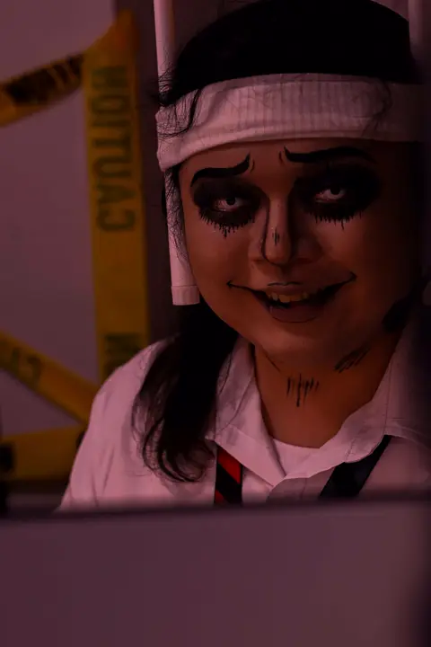 Agent in skull make-up at her desk