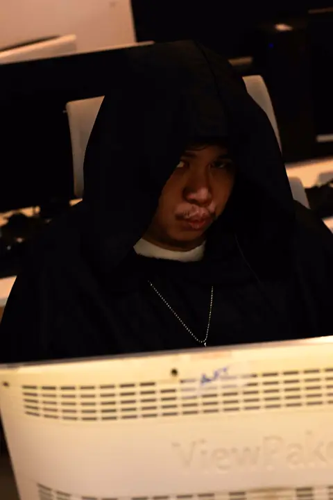 Hooded agent at a workstation